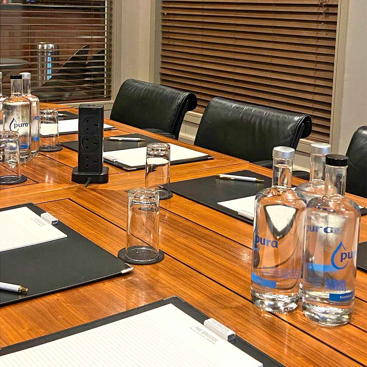 Refillable glass water bottles on conference room table